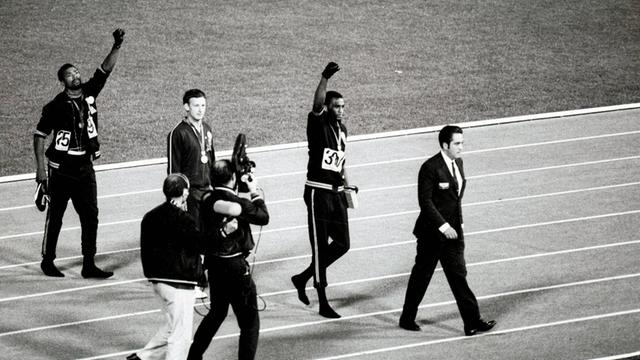 Die US-Athleten Tommie Smith und John Carlos schrieben mit ihrem Black Power-Protest bei der Siegerehrung Geschichte: Bei den Olympischen Spielen in Mexiko, 1968, reckten sie ihre schwarz behandschuhten Fäuste.