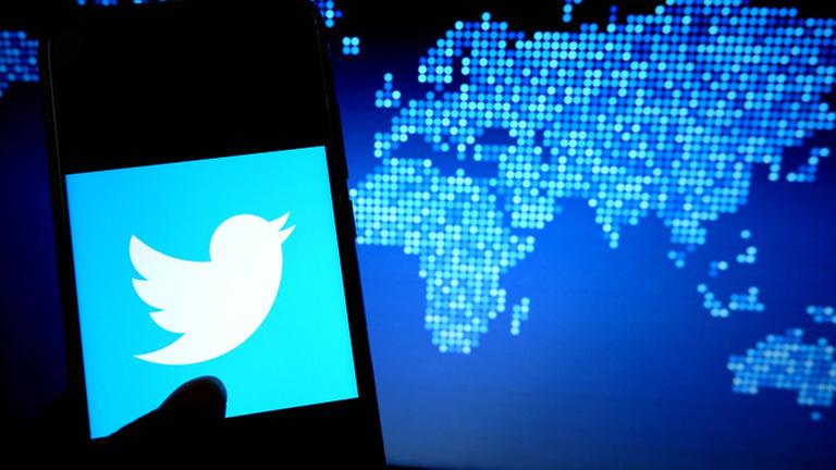 Das Twitter-Logo vor einer Welt-Karte. Das Twitter-Logo vor einer Welt-Karte.
