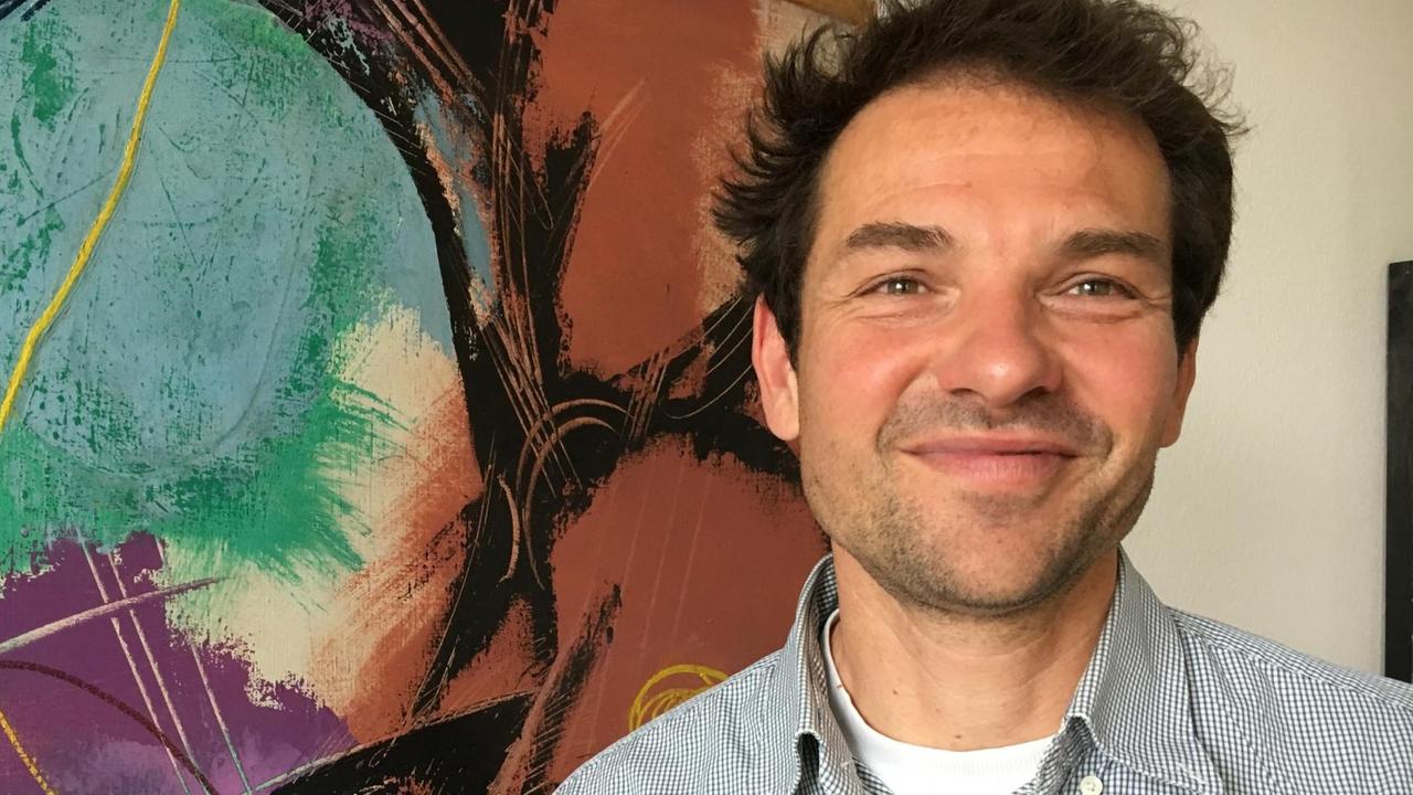 Martin Stümpfing vor einem großflächigen bunten Gemälde Martin Stümpfing vor einem großflächigen bunten Gemälde