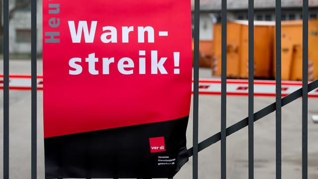 Ein Plakat mit der Aufschrift "Heute: Warnstreik!" hängt in München an einem Tor der Münchner Abfallwirtschaftsbetriebe (AWM).