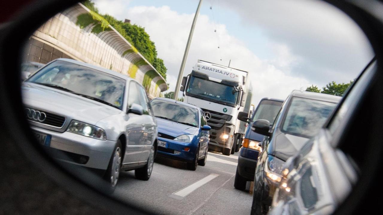 Autos und Lastwagen stehen am 20.06.2015 in Hamburg auf der Autobahn 7 bei Stellingen im Stau und sind dabei durch einen Rückspiegel zu sehen. Autos und Lastwagen stehen am 20.06.2015 in Hamburg auf der Autobahn 7 bei Stellingen im Stau und sind dabei durch einen Rückspiegel zu sehen.