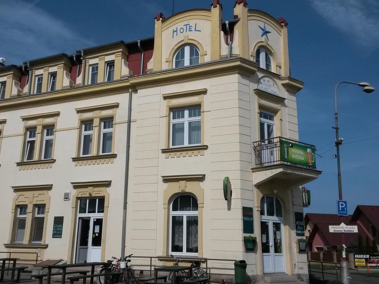 Blick auf ein Hotel, helles altes Gebäude vor blauem Himmel Blick auf ein Hotel, helles altes Gebäude vor blauem Himmel