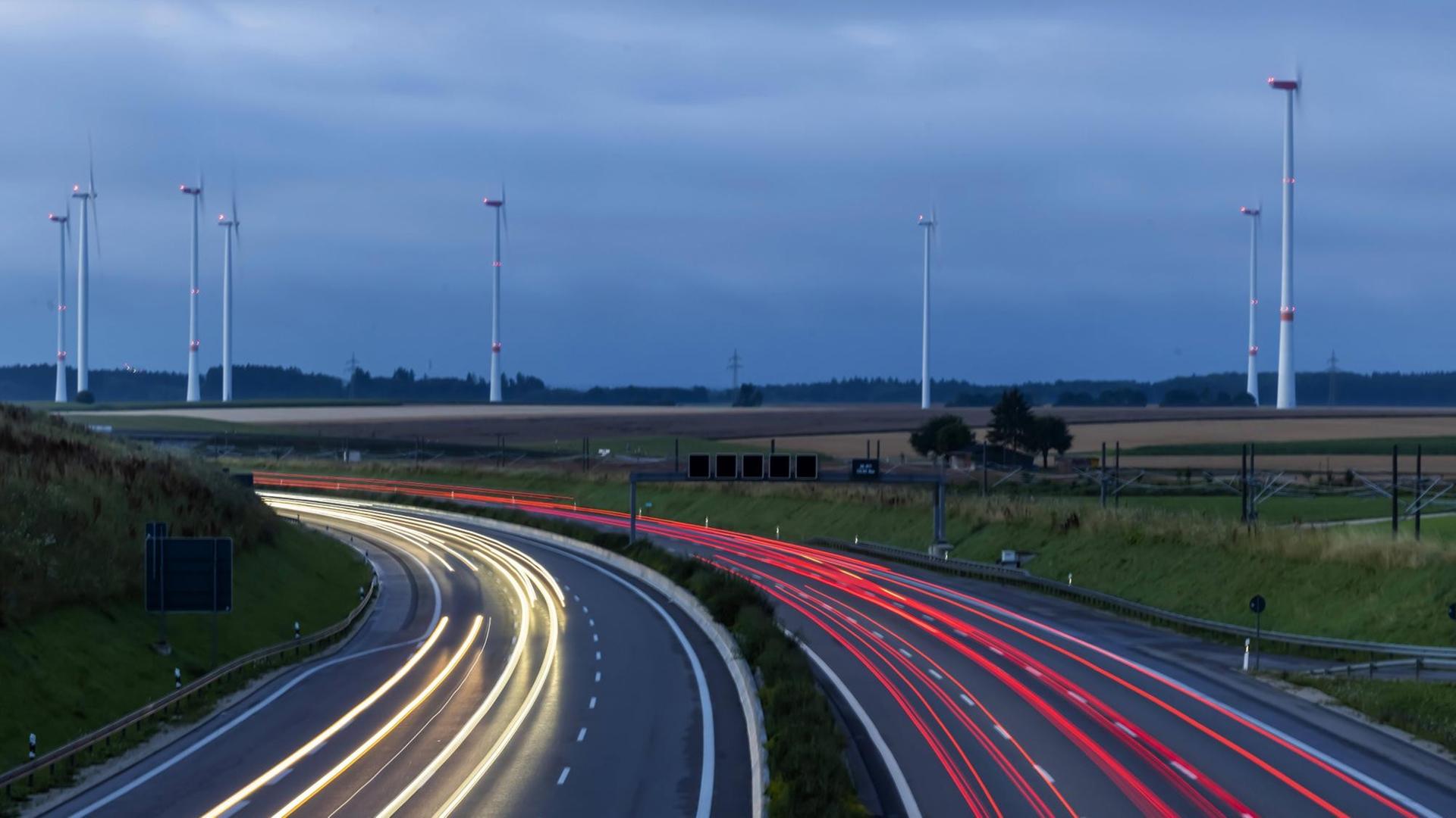 Autobahn A8 am frühen Morgen mit Lichtspuren der Autos. Im Hintergrund ein Windpark. Autobahn A8 am frühen Morgen mit Lichtspuren der Autos. Im Hintergrund ein Windpark.