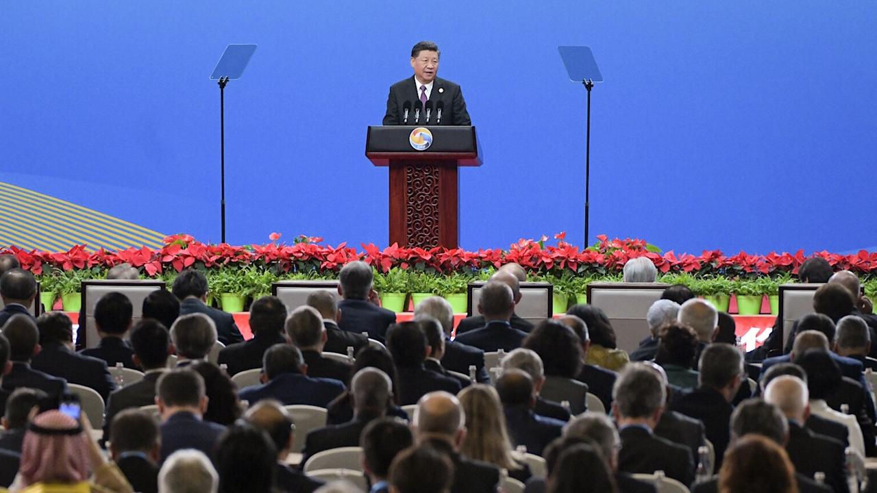 Zu sehen ist Xi Jinping aus großer Entfernung hinter einem Redepult. Im unteren Teil des Bildes sind zahlreiche Delegierte zu sehen, die ihm zuhören.