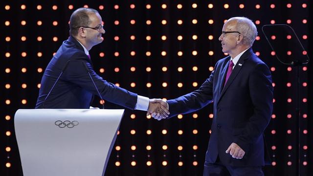 Der damalige Schatzmeister und heutige Präsident von SportAccord/GAISF, Patrick Baumann (l), schüttelt dem Schweizerischen Sportminister Ueli Maurer (r.) während der Präsentation der Kandidatenstädte für die Jugend-Winderspiele 2020 die Hand.
