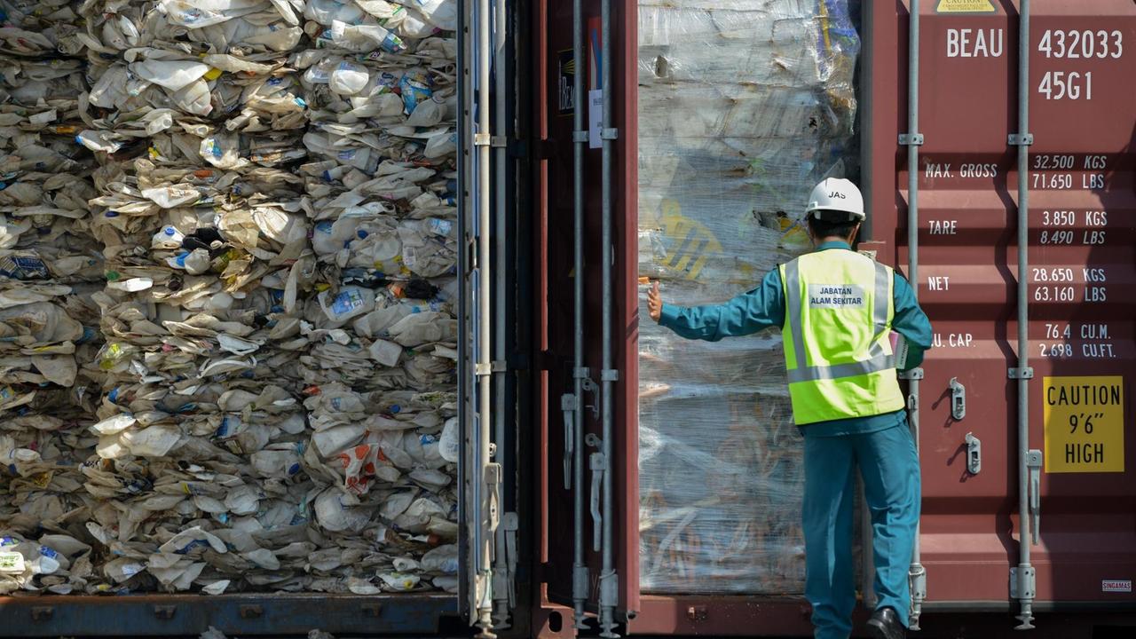 Im Hafen von Port Klang in Malaysia kommt ein Container mit Plastikmüll an. Ein Arbeiter öffnet die Tür. Im Hafen von Port Klang in Malaysia kommt ein Container mit Plastikmüll an. Ein Arbeiter öffnet die Tür.