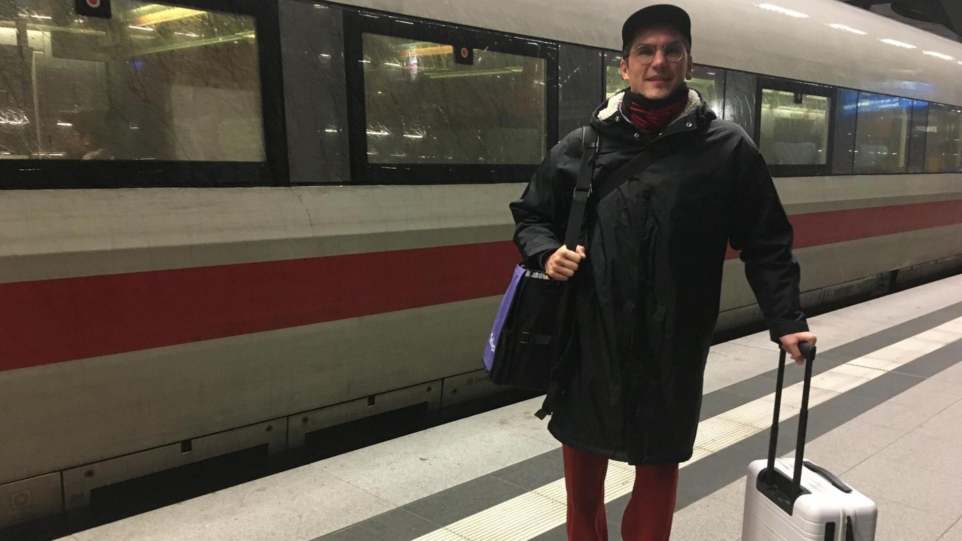 Ein junger Mann - DJ Jakob Mandler - steht vor einem ICE auf dem Bahnsteig. Er hat Gepäck bei sich. Ein junger Mann - DJ Jakob Mandler - steht vor einem ICE auf dem Bahnsteig. Er hat Gepäck bei sich.
