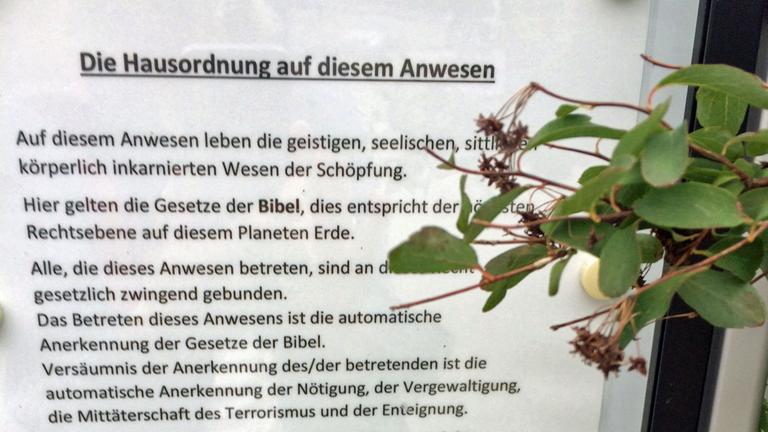 Schaukasten mit dem Text: "Die Hausordnung auf diesem Anwesen. auf diesem anwesen leben die geistigen, sittlichen, körperlich inkarnierten Wesen der Schöpfung. Hier gelten die Gesetze der Bibel, dies entspricht der höchsten Rechtsebene auf diesem Planeten Erde." Schaukasten mit dem Text: "Die Hausordnung auf diesem Anwesen. auf diesem anwesen leben die geistigen, sittlichen, körperlich inkarnierten Wesen der Schöpfung. Hier gelten die Gesetze der Bibel, dies entspricht der höchsten Rechtsebene auf diesem Planeten Erde."