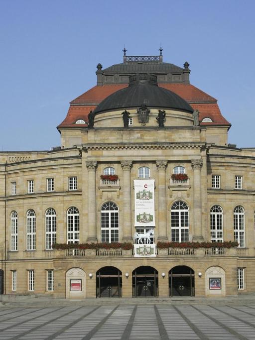 Zu sehen ist das Opernhaus in Chemnitz. Ein Bau im neobarocken Stil. Davor ist ein Platz.