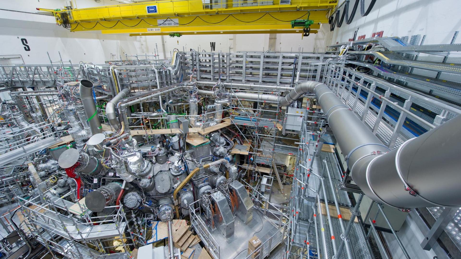 Monteure arbeiten am Max-Planck-Institut für Plasmaphysik in Greifswald (Mecklenburg-Vorpommern) an dem 725 Tonnen schweren, ringförmigen Plasmagefäß für das Kernfusionsexperiment "Wendelstein 7-X". Monteure arbeiten am Max-Planck-Institut für Plasmaphysik in Greifswald (Mecklenburg-Vorpommern) an dem 725 Tonnen schweren, ringförmigen Plasmagefäß für das Kernfusionsexperiment "Wendelstein 7-X".