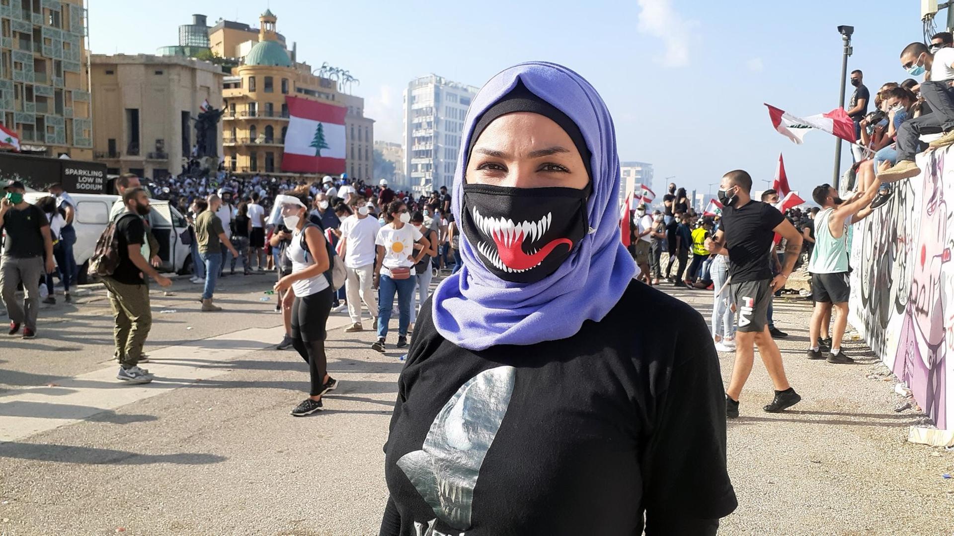 Eine Protestierende mit Maske auf einer Straßendemonstration in Beirut Eine Protestierende mit Maske auf einer Straßendemonstration in Beirut
