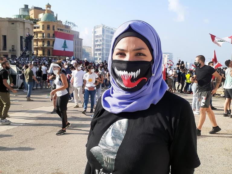 Eine Protestierende mit Maske auf einer Straßendemonstration in Beirut