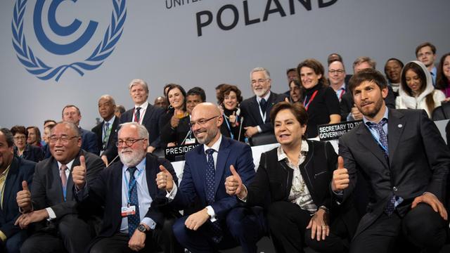 Michal Kurtyka (vorne, M), Präsident der UN-Klimakonferenz COP24, freut sich mit zahlreichen Teilnehmern des Weltklimagipfels über den erreichten Kompromiss. Ziel des Abkommens ist, die Erderwärmung auf deutlich unter zwei Grad zu begrenzen.