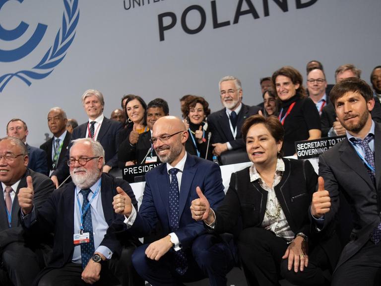 Michal Kurtyka (vorne, M), Präsident der UN-Klimakonferenz COP24, freut sich mit zahlreichen Teilnehmern des Weltklimagipfels über den erreichten Kompromiss. Ziel des Abkommens ist, die Erderwärmung auf deutlich unter zwei Grad zu begrenzen.