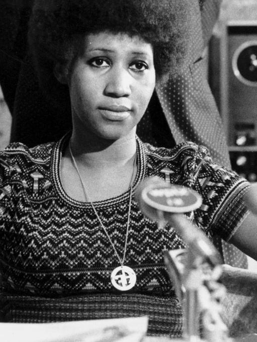 Schwarzweiß-Aufnahme von Aretha Franklin vor einem Mikrofon