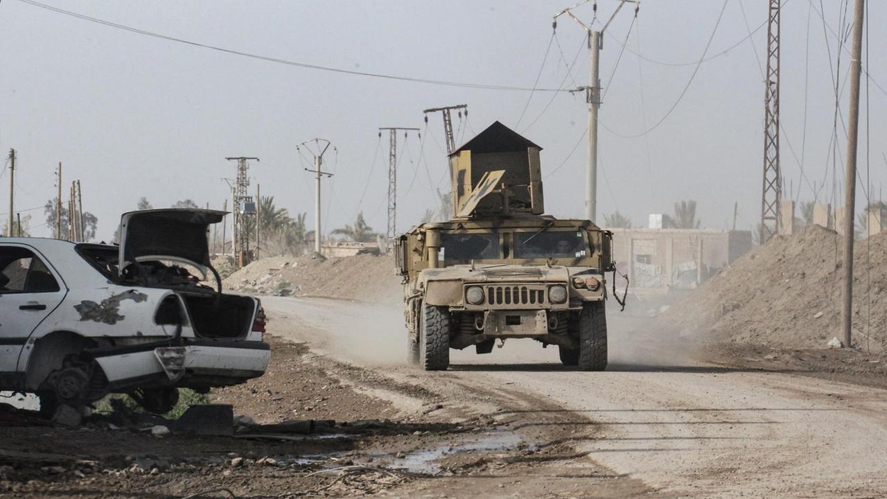 16.02.2019, Syrien, Hadschin: Ein militärisches Geländefahrzeug der von Kurden angeführten und von den USA unterstützten Syrischen Demokratischen Kräfte (SDF) fährt über eine Straße in der kürzlich befreiten Stadt Hadschin.