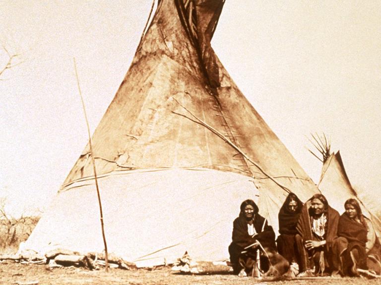 Historische Aufnahme von nordamerikanischen Kiowa-Indianern vor ihrem Tipi. (undatiert)