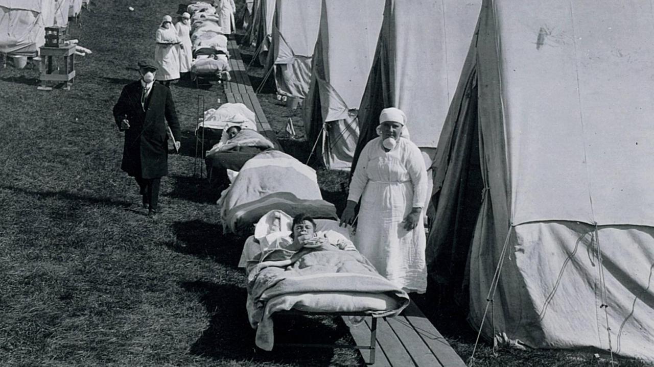 Eine Schwester und mit der Spanischen Grippe Infizierte in einem Notlazarett mit Zelten auf einer Grünfläche in Brookline, Massachusetts, USA, aufgenommen im Oktober 1918. Eine Schwester und mit der Spanischen Grippe Infizierte in einem Notlazarett mit Zelten auf einer Grünfläche in Brookline, Massachusetts, USA, aufgenommen im Oktober 1918.