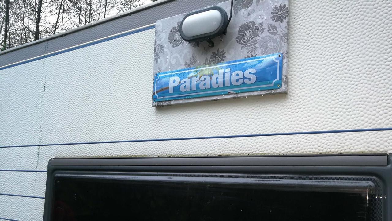 Ein Wohnwagen mit einem Schild, auf dem "Paradies" steht. Ein Wohnwagen mit einem Schild, auf dem "Paradies" steht.