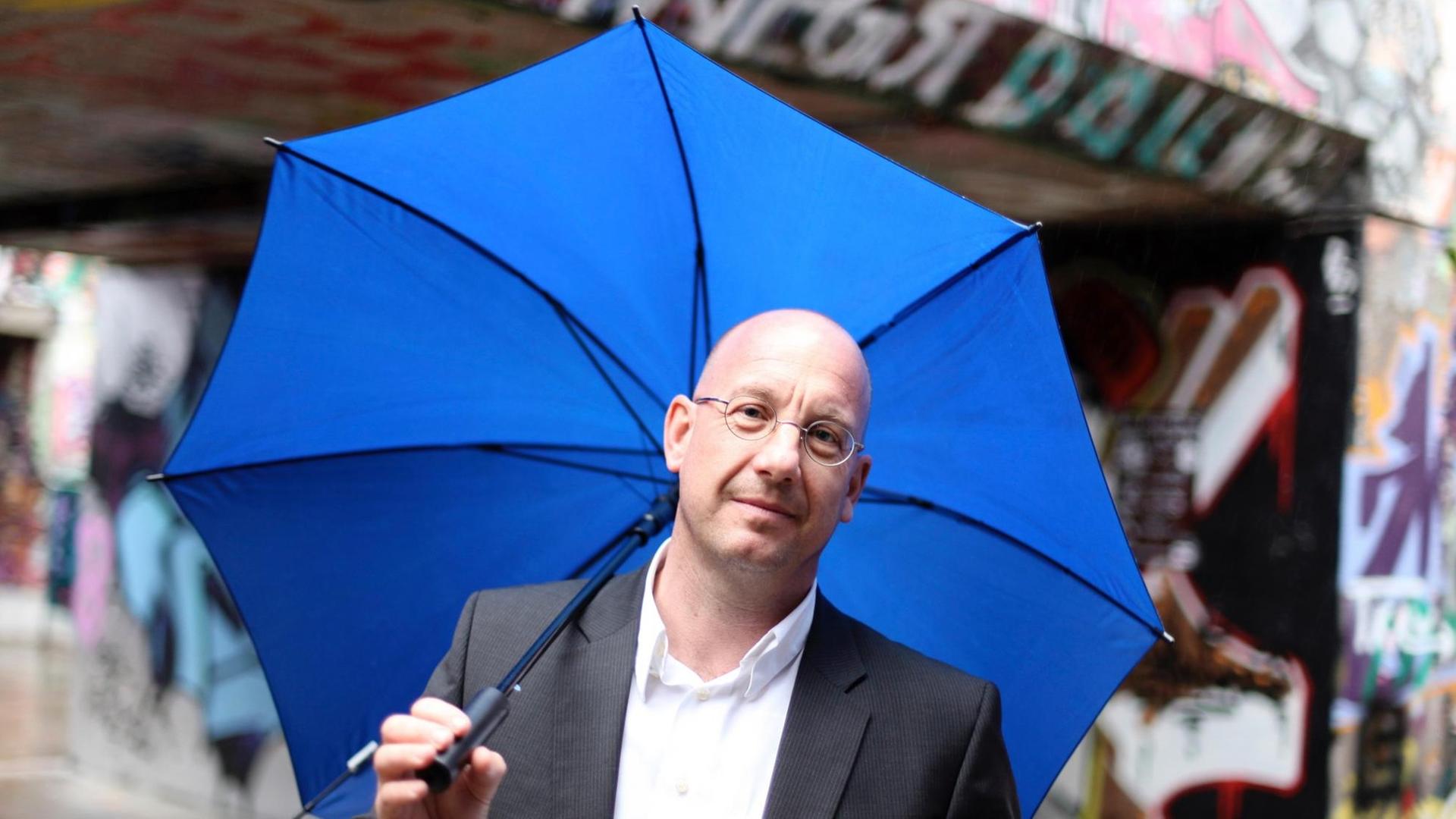 Professor Stefan Selke mit blauem Regenschirm