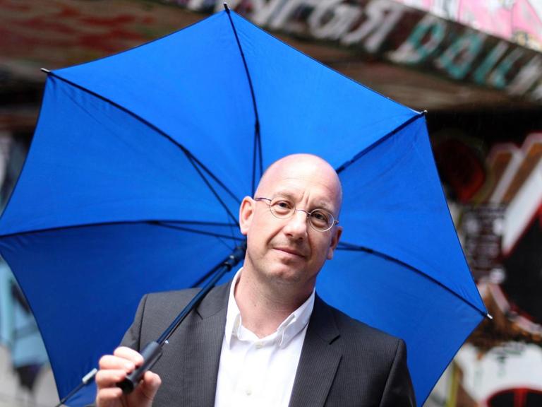 Professor Stefan Selke mit blauem Regenschirm
