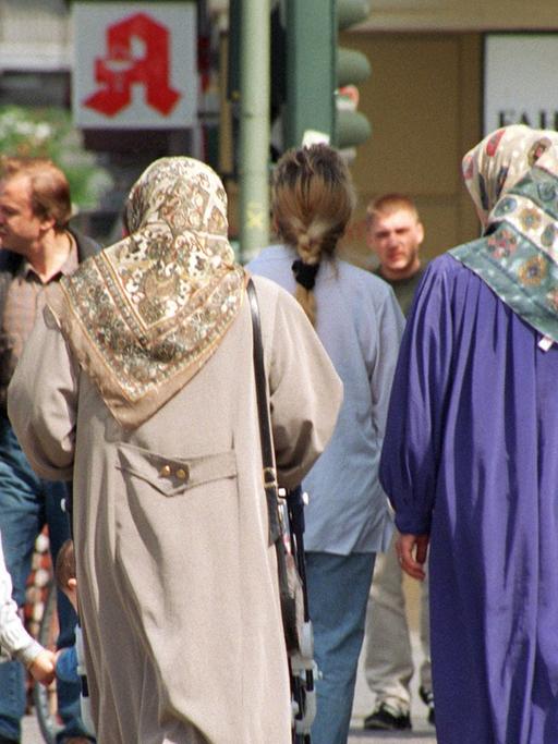 Zwei Frauen mit Kopftuch und andere Fußgänger in Berlin-Kreuzberg