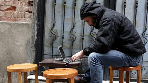 Ein Mann sitzt an einem Laptop
