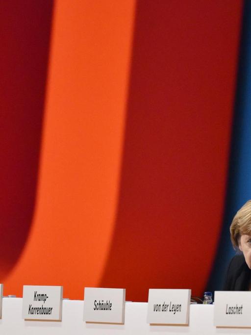 Bundesfinanzminister Wolfgang Schäuble (CDU) sitzt in Karlsruhe (Baden-Württemberg) beim Bundesparteitag neben der CDU-Bundesvorsitzenden und Bundeskanzlerin Angela Merkel.