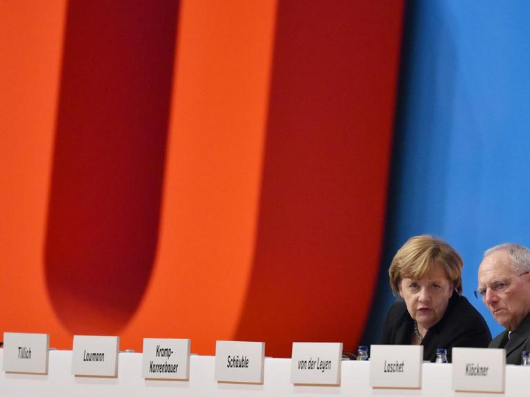Bundesfinanzminister Wolfgang Schäuble (CDU) sitzt in Karlsruhe (Baden-Württemberg) beim Bundesparteitag neben der CDU-Bundesvorsitzenden und Bundeskanzlerin Angela Merkel.