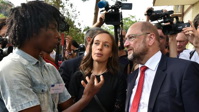 SPD-Kanzlerkandidat Martin Schulz spricht mit einem Flüchtling in einer Einrichtung in Catania/ Italien.
