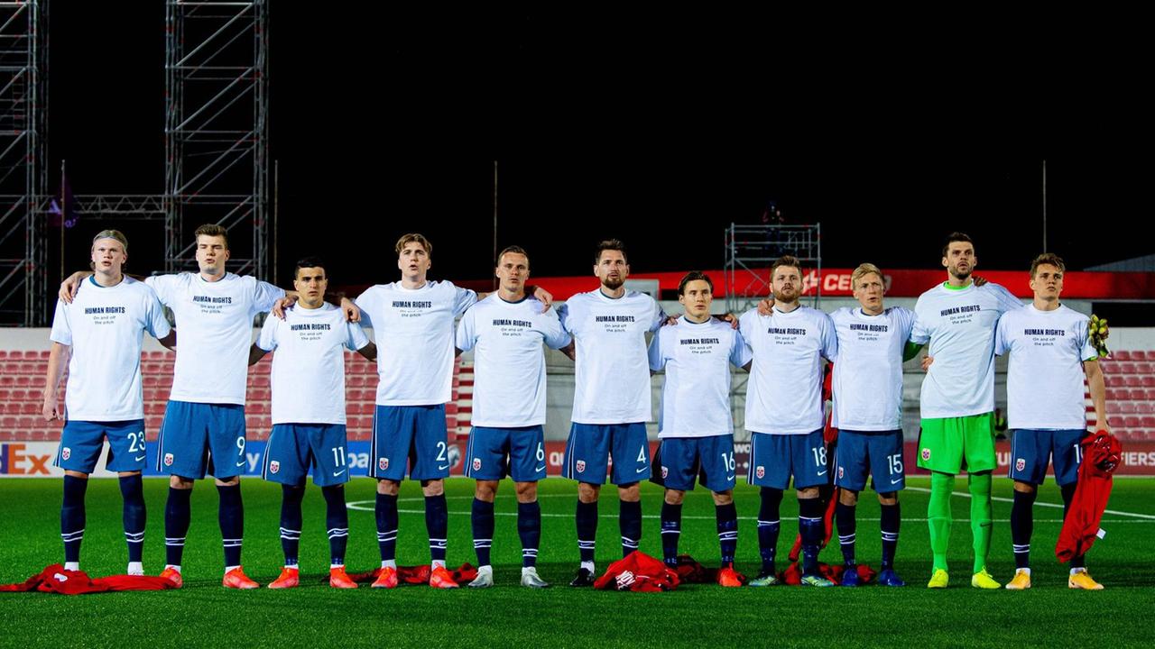 Die Spieler stehen Arm in Arm und tragen T-Shirts mit der Aufschrift "Menschenrechte - auf und neben dem Platz". Die Spieler stehen Arm in Arm und tragen T-Shirts mit der Aufschrift "Menschenrechte - auf und neben dem Platz".