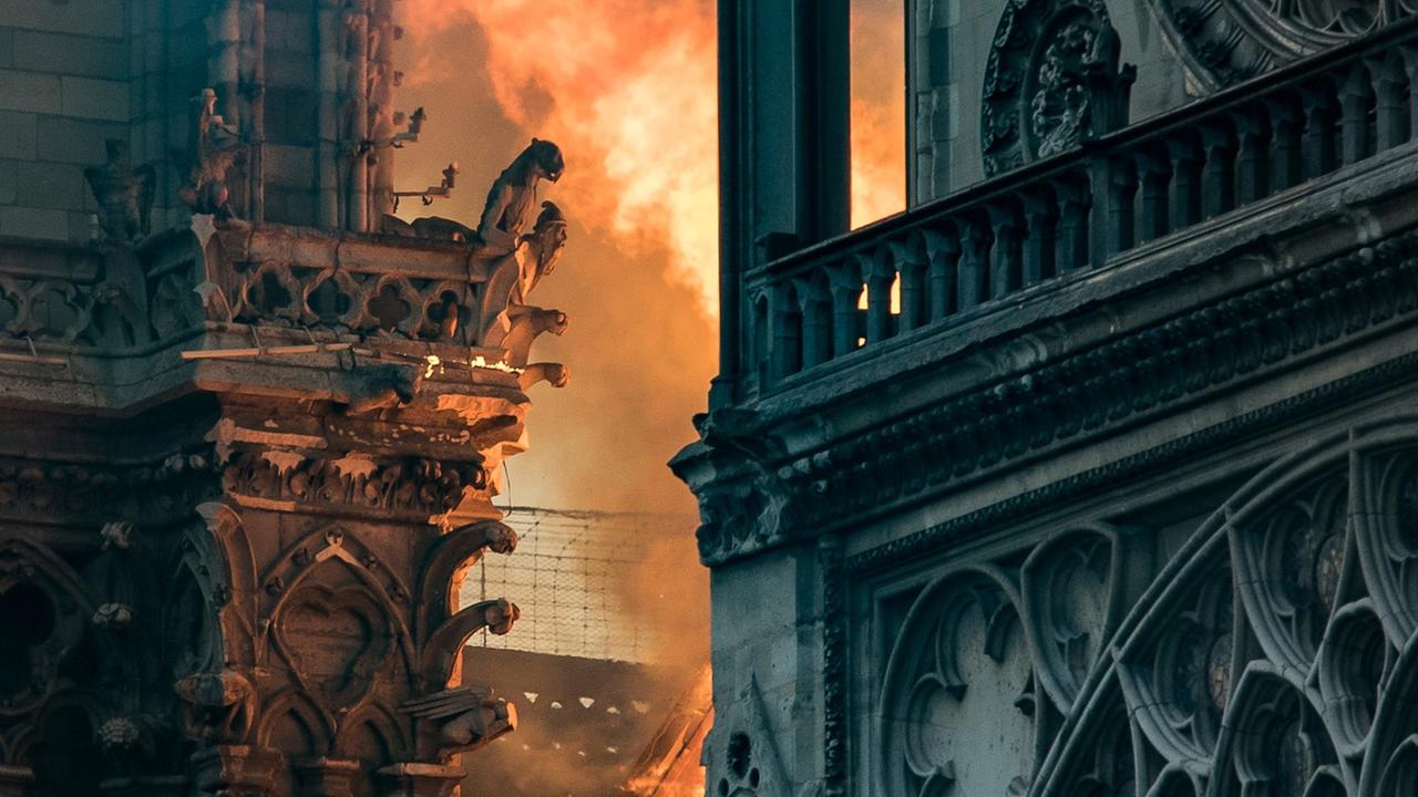 Flammen und Rauch rund um den gotischen Wasserspeicher der Kathredrale Notre-Dame in Paris, aufgenommen am 15. April 2019.