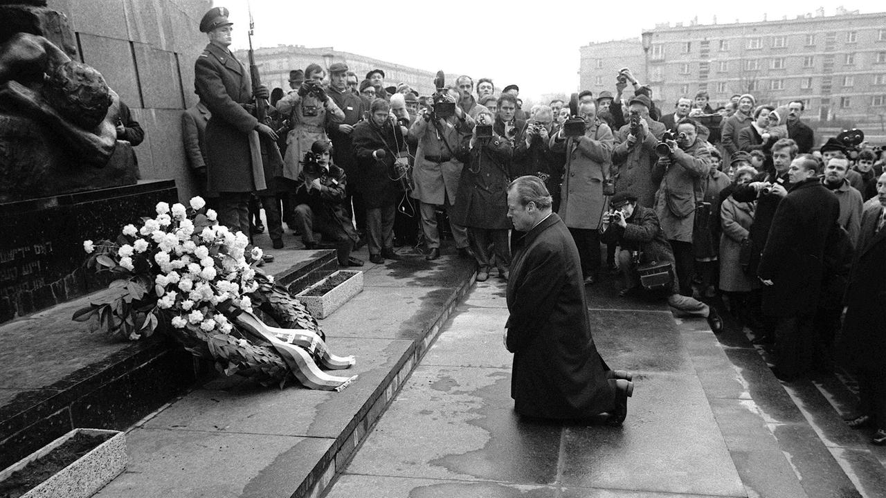 Bundeskanzler Willy Brandt kniet umringt von Journalisten vor dem Denkmal für die Opfer des Warschauer Ghettos in Warschau im Jahr 1970