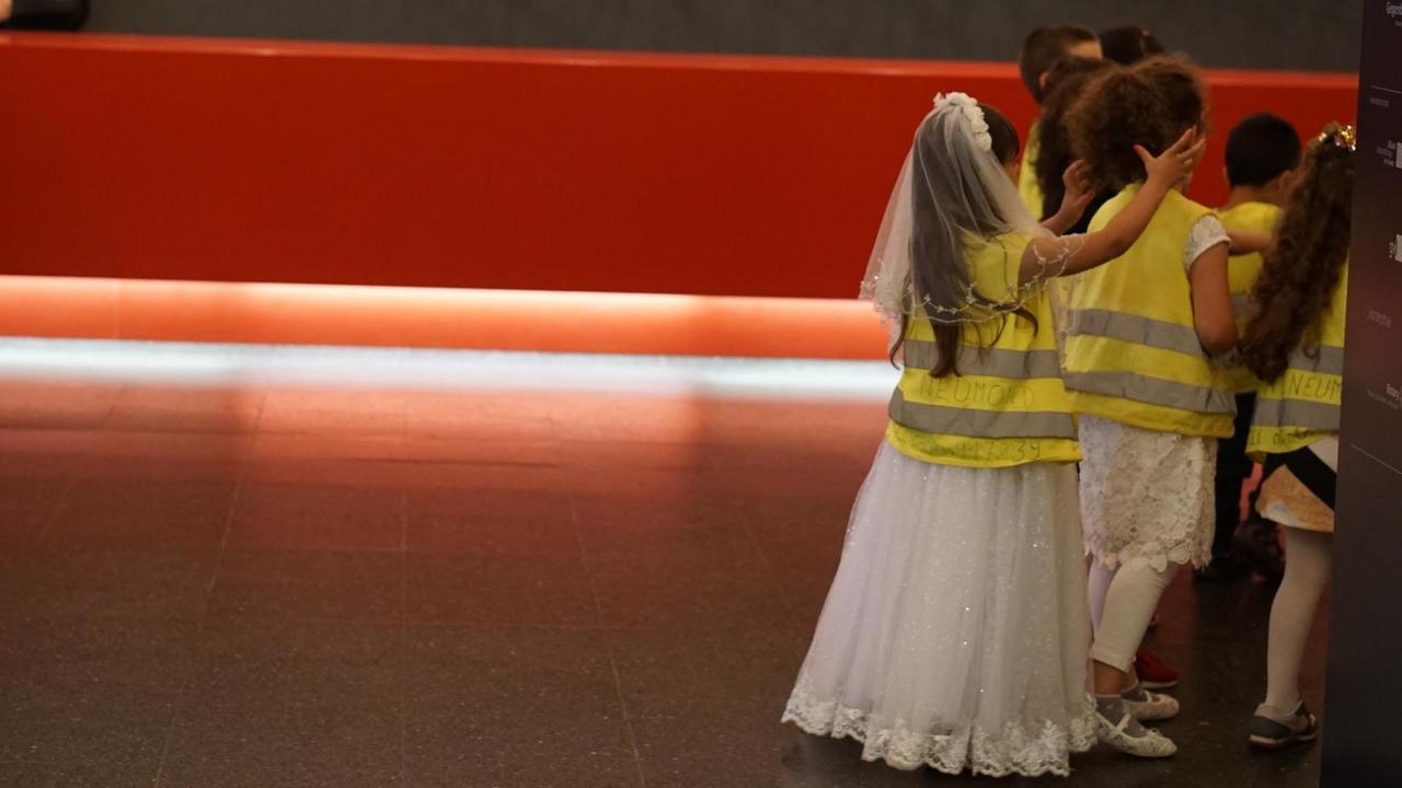 Die Kinder auf dem Weg hinter die Bühne. Sie tragen gelbe Westen. Die Kinder auf dem Weg hinter die Bühne. Sie tragen gelbe Westen.