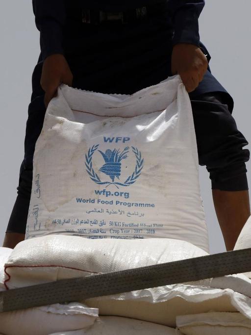 23. Juni 2019: Ein Sack mit Hilfsgütern des Welternährungsprogramms in Sanaa, Jemen, und ein Mann
