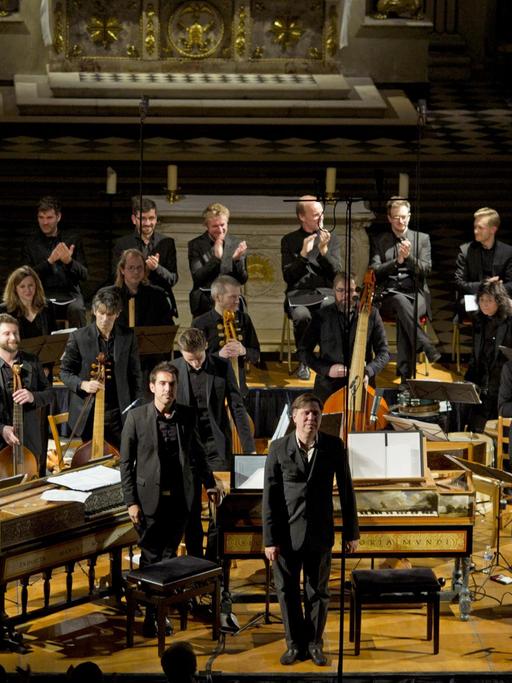 Das Orchester steht mit historischen Instrumenten auf einer Bühne.