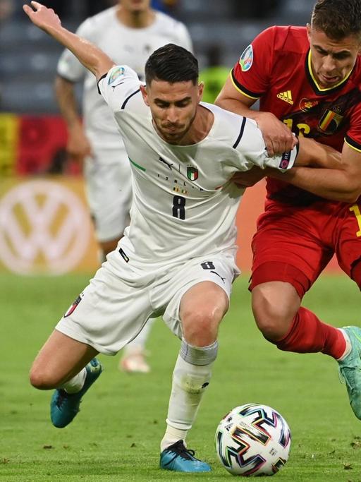 Fußball-EM: Belgien spielt im Viertelfinale gegen Italien. Der belgische Spieler Thorgan Hazard und Italiens Jorginho kämpfen um den Ball.