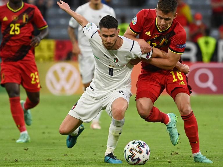 Fußball-EM: Belgien spielt im Viertelfinale gegen Italien. Der belgische Spieler Thorgan Hazard und Italiens Jorginho kämpfen um den Ball.