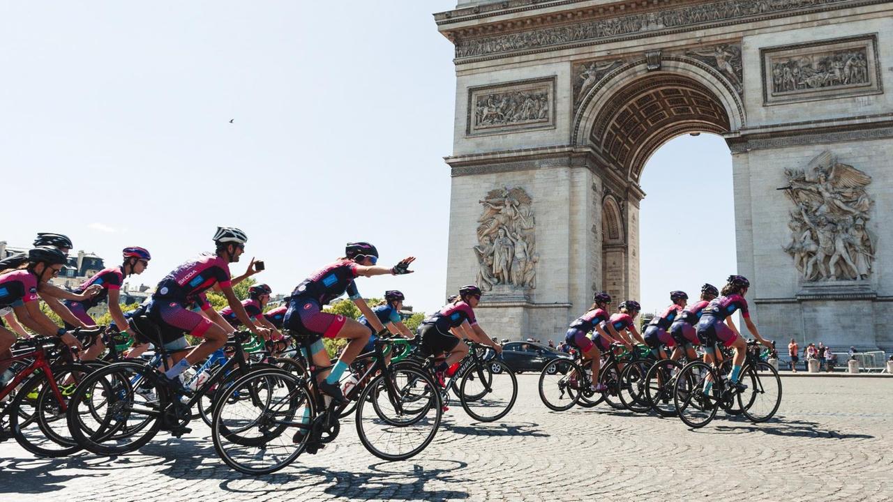 Eine Gruppe von Radfahrerinnen vor dem Arc de Triomphe.