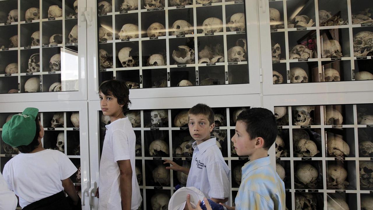 Schüler im Mausoleum in Distomo, fotografiert vor einer Wand mit Knochen von 218 Männern, Frauen und Kindern, umgebracht von den Nazis, um Widerstand gegen die NS-Besatzer zu vergelten Schüler im Mausoleum in Distomo, fotografiert vor einer Wand mit Knochen von 218 Männern, Frauen und Kindern, umgebracht von den Nazis, um Widerstand gegen die NS-Besatzer zu vergelten