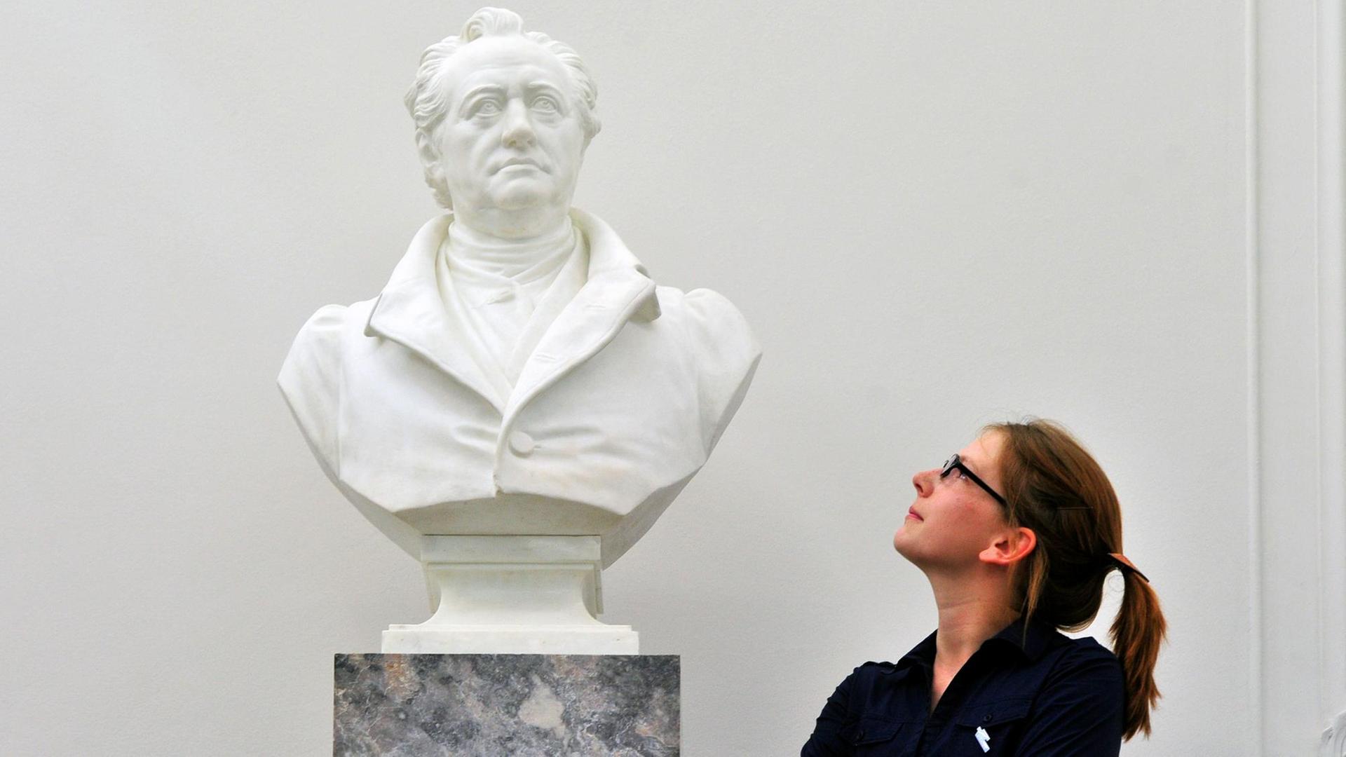 Eine junge Frau betrachtet im Goethe- und Schiller-Archiv in Weimar eine Porträtbüste von Johann Wolfgang Goethe.