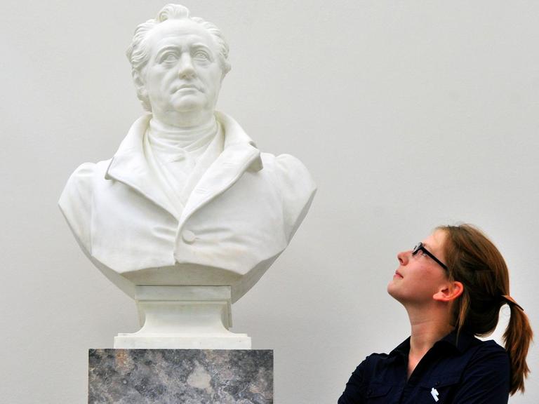 Eine junge Frau betrachtet im Goethe- und Schiller-Archiv in Weimar eine Porträtbüste von Johann Wolfgang Goethe.