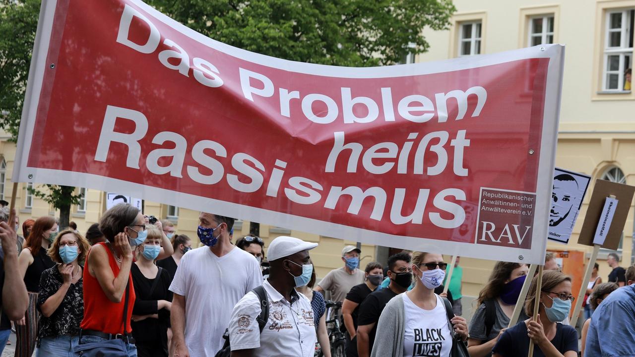 Menschen mit Plakat "Das Problem heißt Rassismus": Demonstration gegen Rassismus, zum Gedenken der Opfer von Hanau. Menschen mit Plakat "Das Problem heißt Rassismus": Demonstration gegen Rassismus, zum Gedenken der Opfer von Hanau.