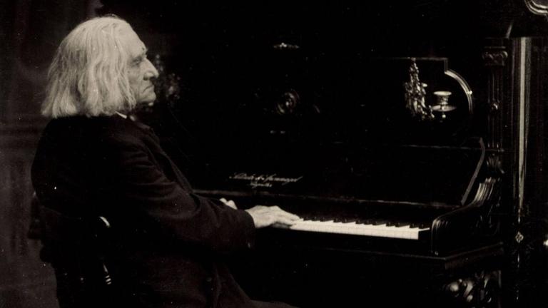 Fotographie des Komponisten, der an einem Klavier sitzt. Fotographie des Komponisten, der an einem Klavier sitzt.