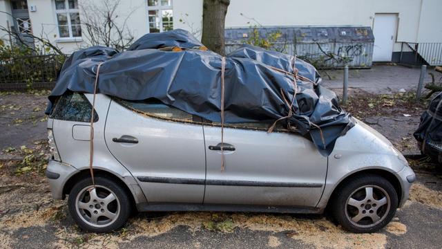 Ein Auto mit Sturmschaden steht am 30.10.2017 in Hamburg-Barmbek in einer Straße. Sturmtief "Herwart" hat für zahlreiche Schäden gesorgt. Foto: Daniel Bockwoldt/dpa | Verwendung weltweit