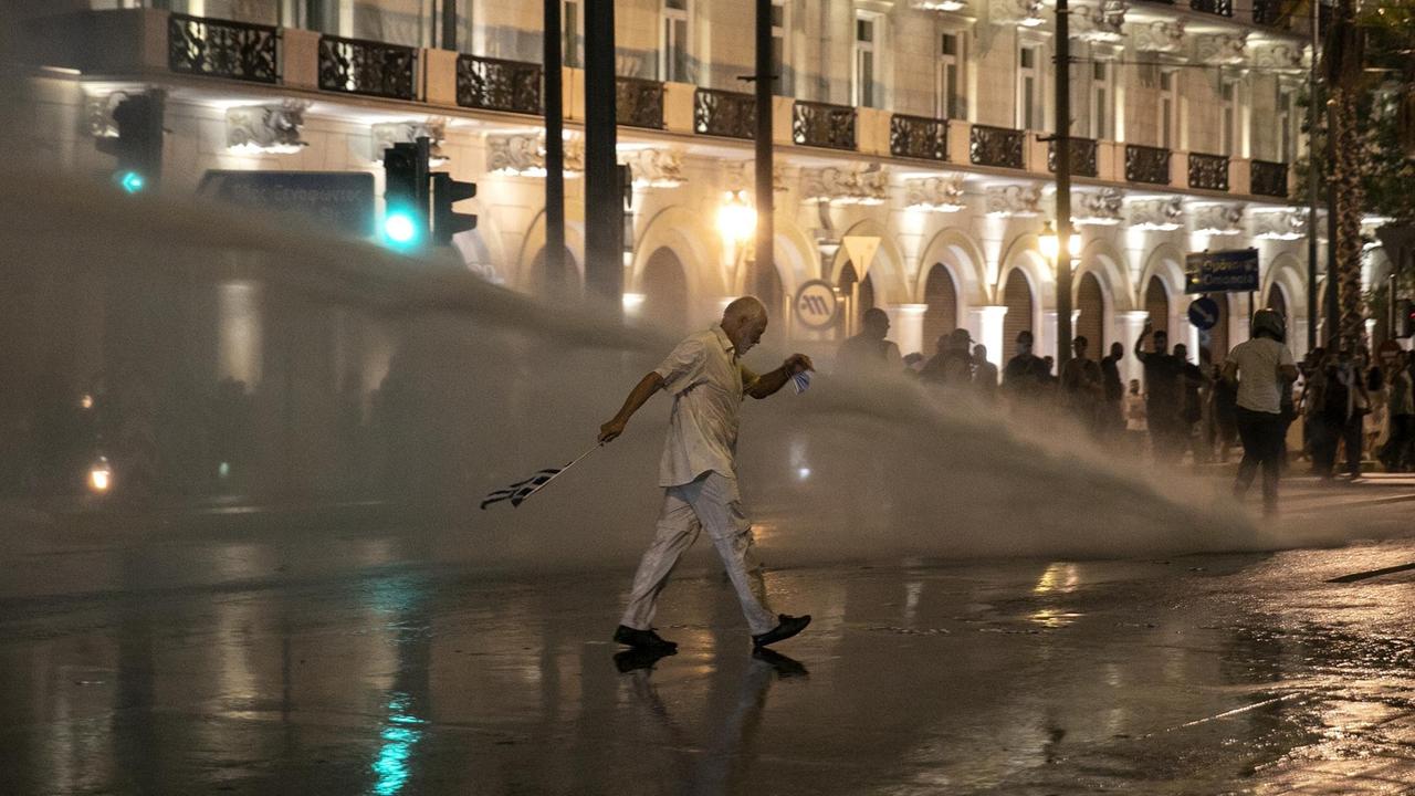 Die griechische Polizei setzt während einer Kundgebung gegen die Corona-Regeln auf dem Syntagma-Platz im Zentrum Athens einen Wasserwerfer ein. Die griechische Polizei setzt während einer Kundgebung gegen die Corona-Regeln auf dem Syntagma-Platz im Zentrum Athens einen Wasserwerfer ein.