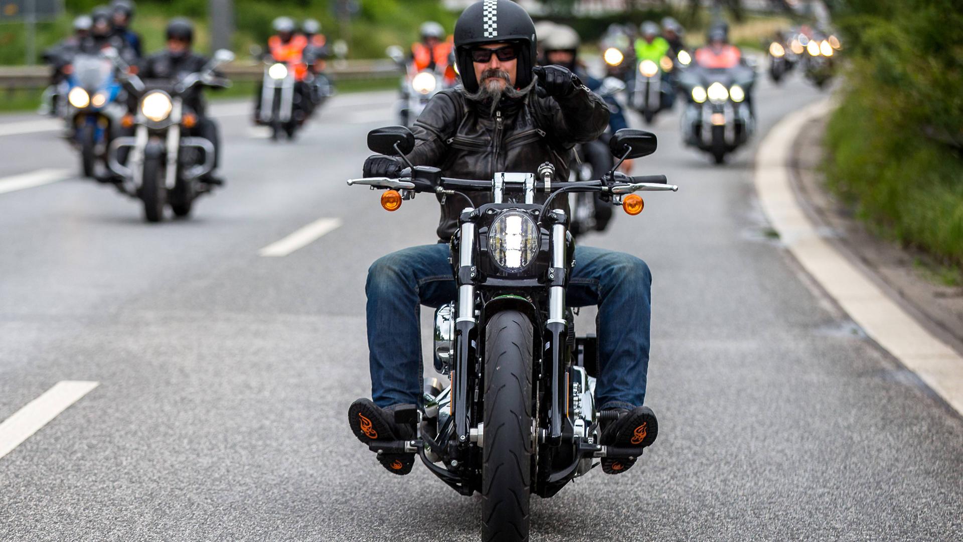 Auf dem Foto fahren zahlreiche Harley Davidson-Fahrer auf den Fotografen zu. Im Vordergrund ist ein Fahrer mit einem gezwirbelten grauen Backenbart im Gesicht. Auf dem Foto fahren zahlreiche Harley Davidson-Fahrer auf den Fotografen zu. Im Vordergrund ist ein Fahrer mit einem gezwirbelten grauen Backenbart im Gesicht.