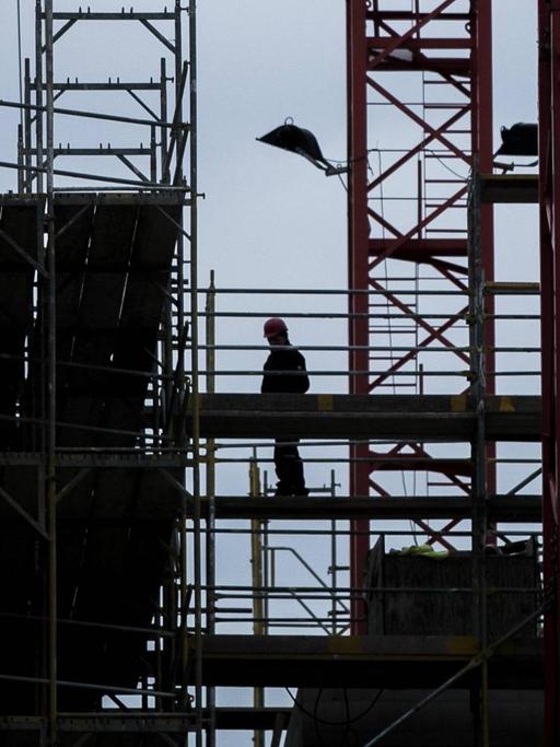 Ein Bauarbeiter steht am 15. 01. 2019 auf einem Baugeruest in Berlin.