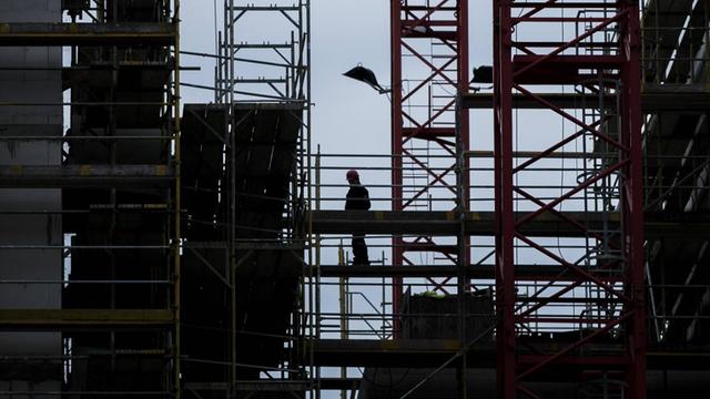 Ein Bauarbeiter steht am 15. 01. 2019 auf einem Baugeruest in Berlin.