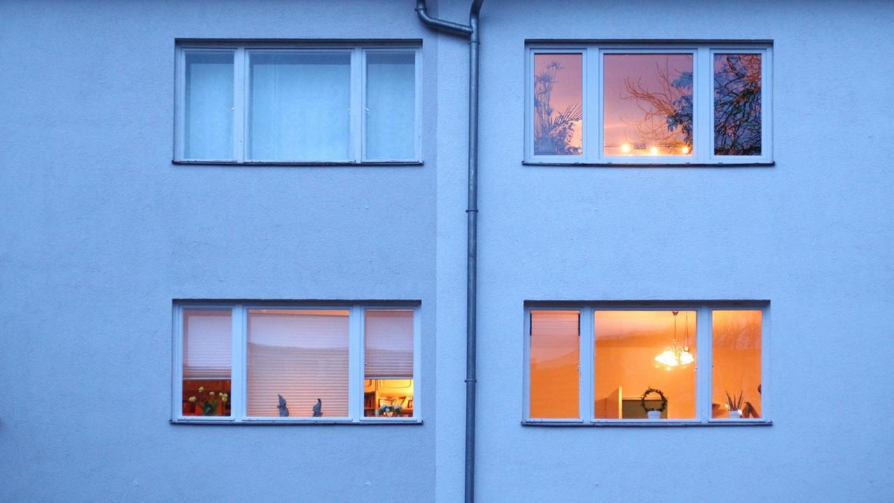 Berlin. In einem Mehrfamilienhaus im Bezirk Steglitz-Zehlendorf sind in der Abenddämmerung bereits einige Fenster erleuchtet. Berlin. In einem Mehrfamilienhaus im Bezirk Steglitz-Zehlendorf sind in der Abenddämmerung bereits einige Fenster erleuchtet.